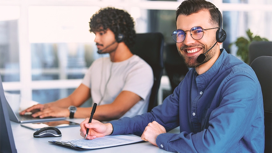 two people with headphones on doing customer support two people with headphones on doing customer support