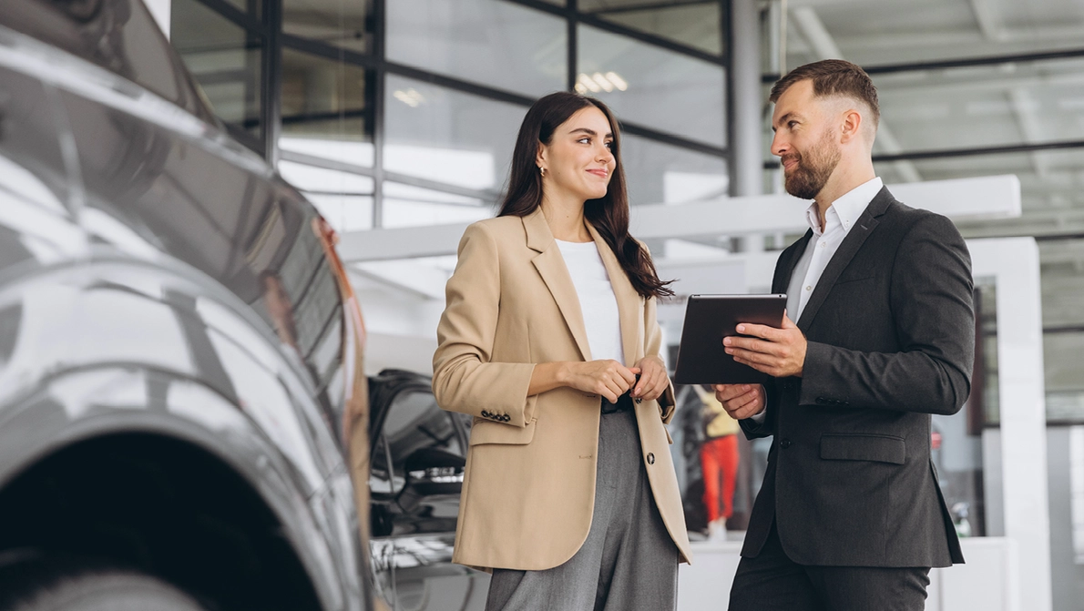 KOMSA DaaS 2025 Autohandel links oben Titelbild Autohändler berät Kundin zu neuen PKW