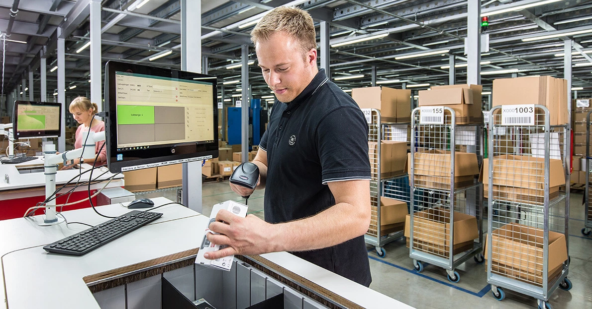 KOMSA logistics employee scans goods KOMSA logistics employee scans goods