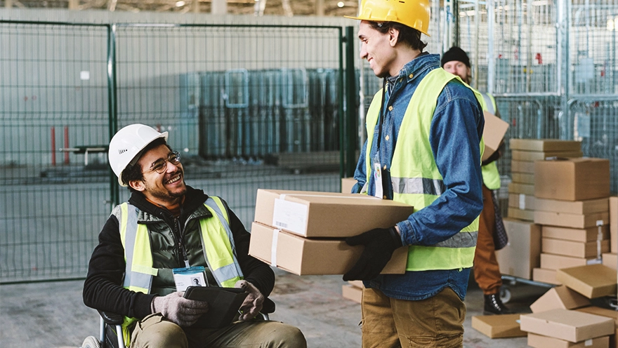 two people in a warehouse. One person is holding a parcel and is chatting with the other person. two people in a warehouse. One person is holding a parcel and is chatting with the other person.